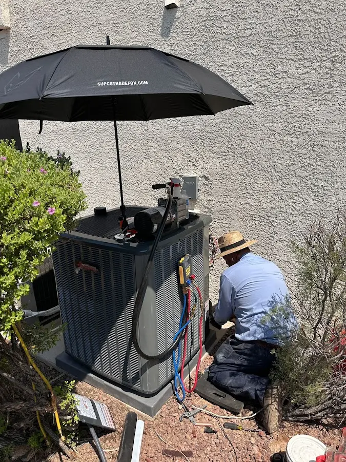 HVAC technician performing outdoor AC maintenance in Biddeford